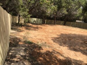 A long wood privacy fence enclosing a large dirt lot, installed by Backyard Builders in Rockford, MI.