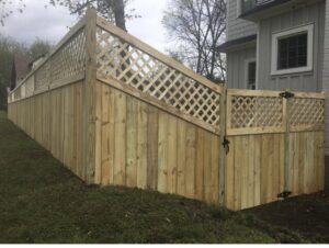 A custom wood privacy fence featuring a decorative lattice top and a matching gate, installed by Holmes Fence Company in Chattanooga, TN.
