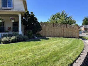 A wood privacy fence with a decorative lattice top installed for a residential yard by Prestige Fencing LLC in Medford, OR.