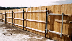A wood privacy fence with sturdy metal posts and a gate, installed by Fence Tech in Everett, WA.