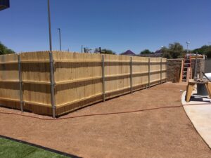 A newly installed wood privacy fence with sturdy metal posts by SFA Contracting LLC, a fencing contractor in Tucson, AZ.