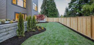 A long wooden privacy fence installed alongside a modern home and landscaped yard by Western Fence & Landscape Supply in Caldwell, ID.