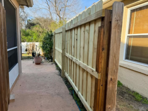 A new wood privacy fence installed alongside a residential home by Native Outdoors, LLC in Orlando, FL.