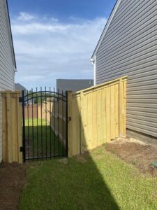 A wood privacy fence combined with a decorative ornamental iron gate by Covenant Fence in Columbia, SC.