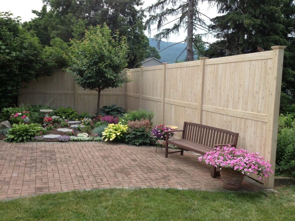 A natural wood privacy fence enclosing a brick patio and garden area by Longhorn Fencing Eastern Idaho in Pocatello, ID.