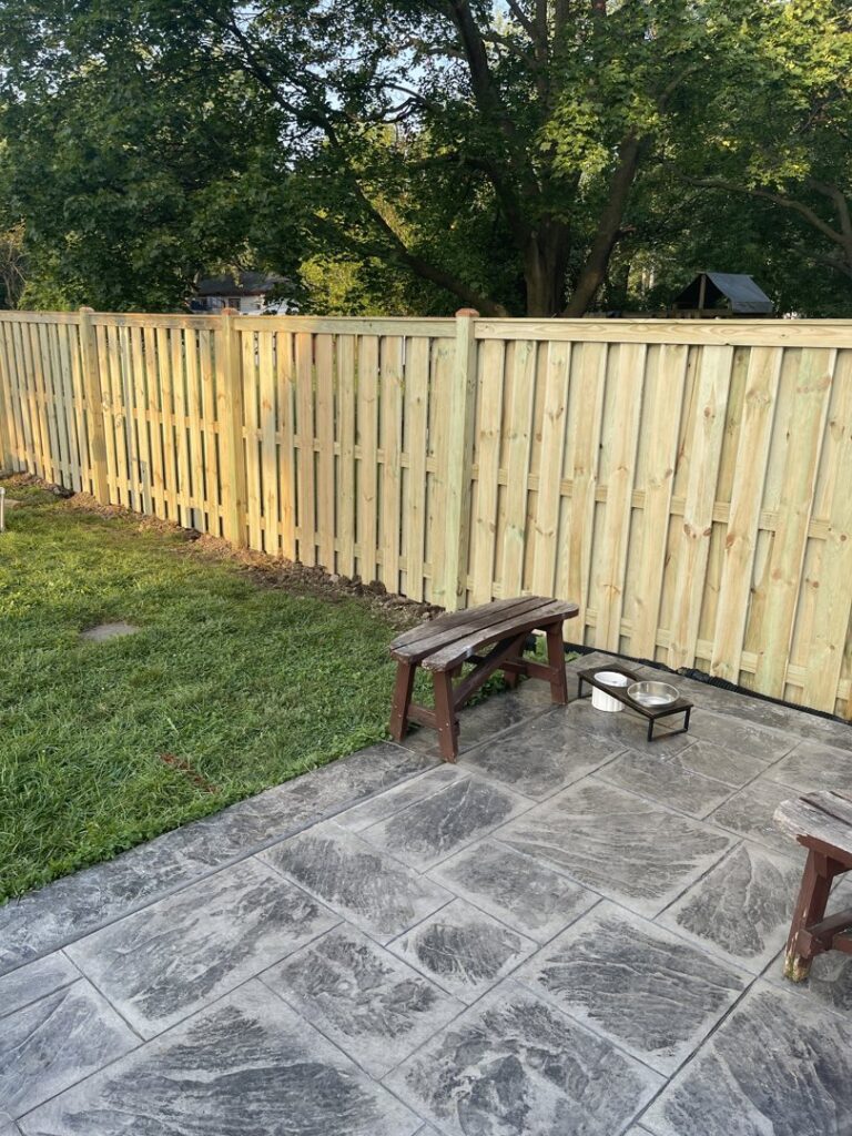 Wood privacy fence installed next to a backyard patio by All Terrain Fence LLC in Waukegan, IL