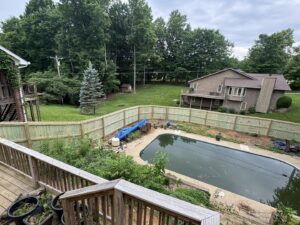 A long wooden privacy fence installed around a pool area by Shatkoff Fencing in Louisville, KY.