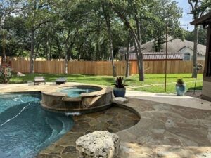 A wood privacy fence installed in a backyard with a pool by Liberty Fence & Stain in San Antonio, TX.