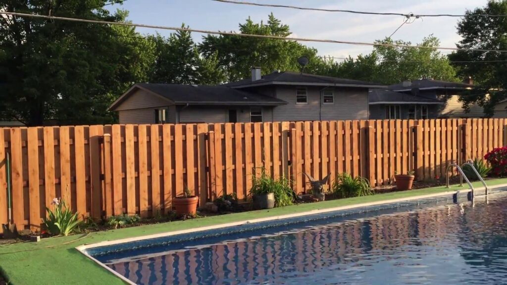 A wood privacy fence installed alongside a swimming pool by Cedar Mountain Fence Company in Plainfield, IL.