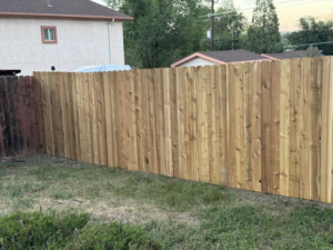 A new wood privacy fence installed in a grassy backyard by HG Fencing LLC in Fountain, CO.