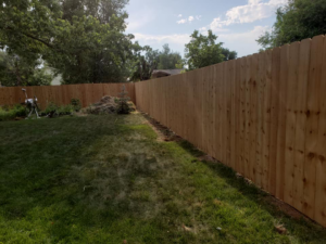 A tall wood privacy fence installed in a residential backyard, showcasing work by JBC Services LLC in Milwaukee, WI.