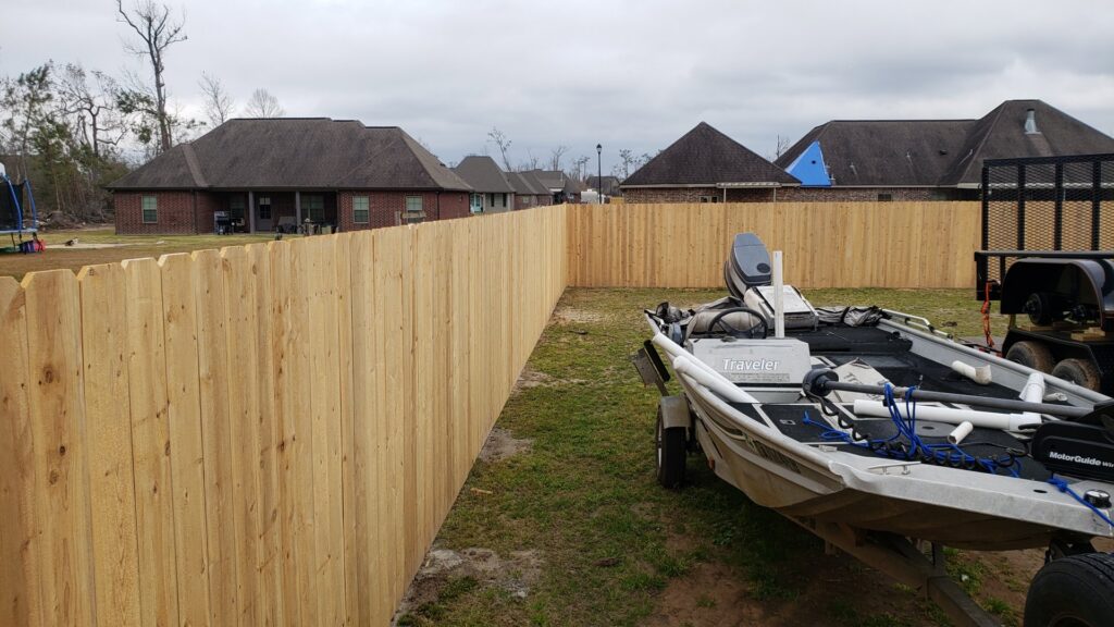 A new wooden privacy fence enclosing a residential backyard, installed by JH Fencing in Lawrence, KS.
