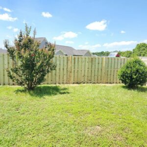 A section of newly installed wood privacy fence in a residential yard by Fencingphd.nc in Fayetteville, NC.