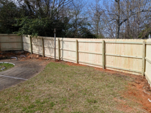 A section of newly installed wood privacy fence in a residential backyard by Top Rail Fence Birmingham, AL