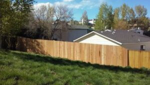 A newly installed wood privacy fence on a sloped residential yard by Done Wright Fencing and Welding in Denver, CO.
