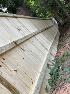 A new wood privacy fence installed on a steep slope by Right Now Fencing, LLC in Johns Creek, GA