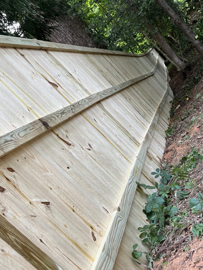 A new wood privacy fence installed on a steep slope by Right Now Fencing, LLC in Johns Creek, GA