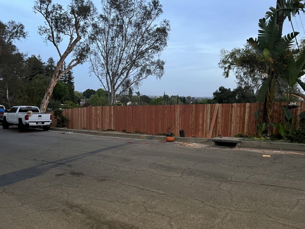 A long wood privacy fence being installed along a residential street by True American Fence Supply and Construction in Anaheim, CA.