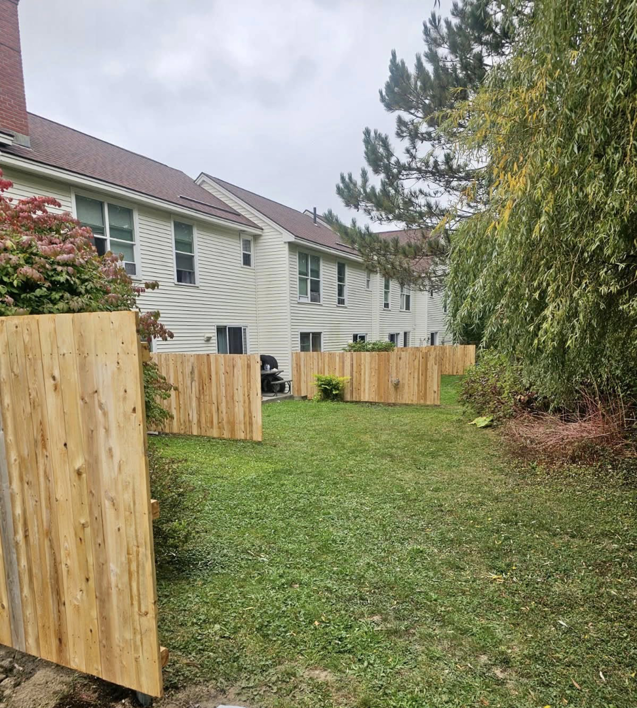 Wood privacy fencing installed in a townhouse backyard, providing separation by Dirigo Fence Company in Augusta, ME.