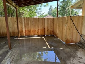 A wood privacy fence with a gate installed under a covered patio area by 208 Fence and Gate in Idaho Falls, ID.