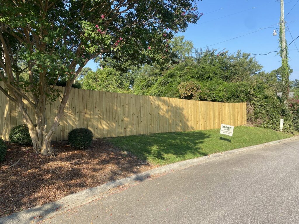 A newly installed wood privacy fence with a Covenant Fence business sign in Columbia, SC.