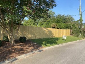A newly installed wood privacy fence with a Covenant Fence business sign in Columbia, SC.