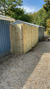 A newly installed wood privacy fence with a gate by Higdon's fence install & repair in White Mills Junction, KY