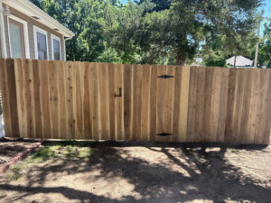 A newly installed wood privacy fence with a gate by NC Fencing LLC in Wichita, KS.