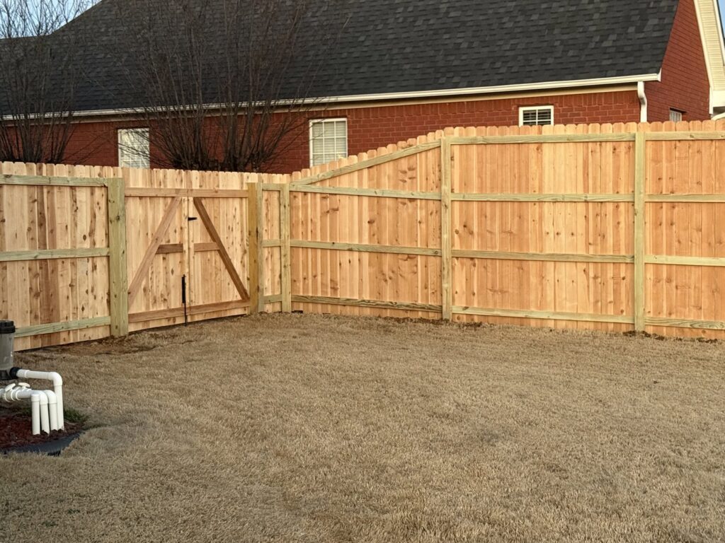 A wooden privacy fence featuring a sturdy gate, installed by Integrity Fence & Outdoor Company in Jackson, TN.