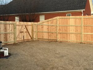 A wooden privacy fence featuring a sturdy gate, installed by Integrity Fence & Outdoor Company in Jackson, TN.