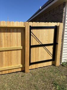 A residential wood privacy fence with a sturdy gate, expertly installed by 985 Fence, LLC in Schriever, LA.