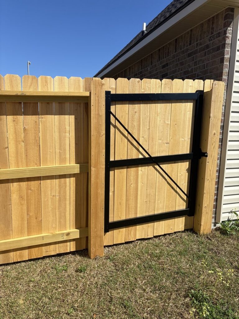A residential wood privacy fence with a sturdy gate, expertly installed by 985 Fence, LLC in Schriever, LA.