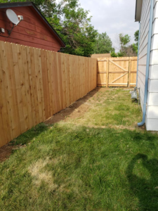 A wood privacy fence with a matching gate installed in a narrow side yard by JBC Services LLC in Milwaukee, WI.