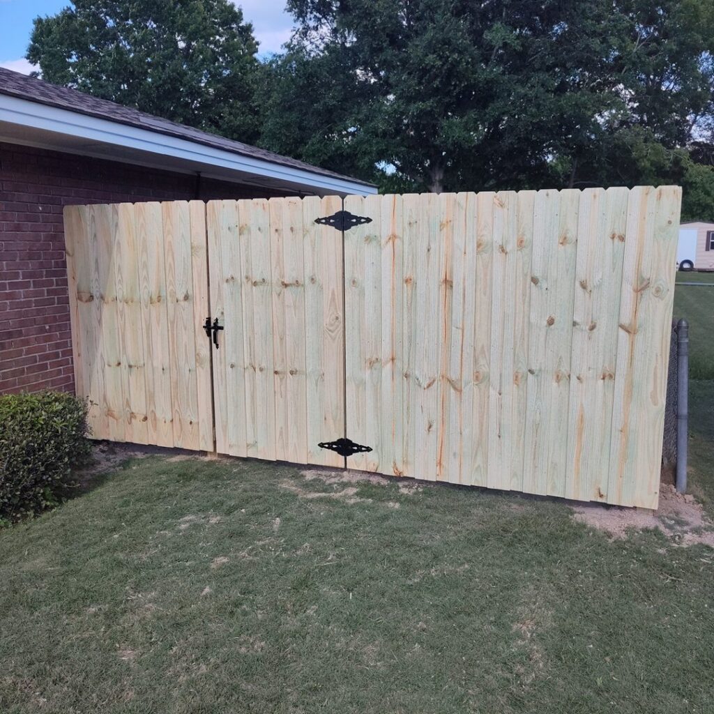 A newly installed wood privacy fence with a gate, enhancing a home's perimeter by The Fence Dudes in Birmingham, AL.