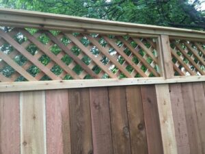 A newly installed wood privacy fence with a decorative lattice top by City Fence Co of San Antonio, TX
