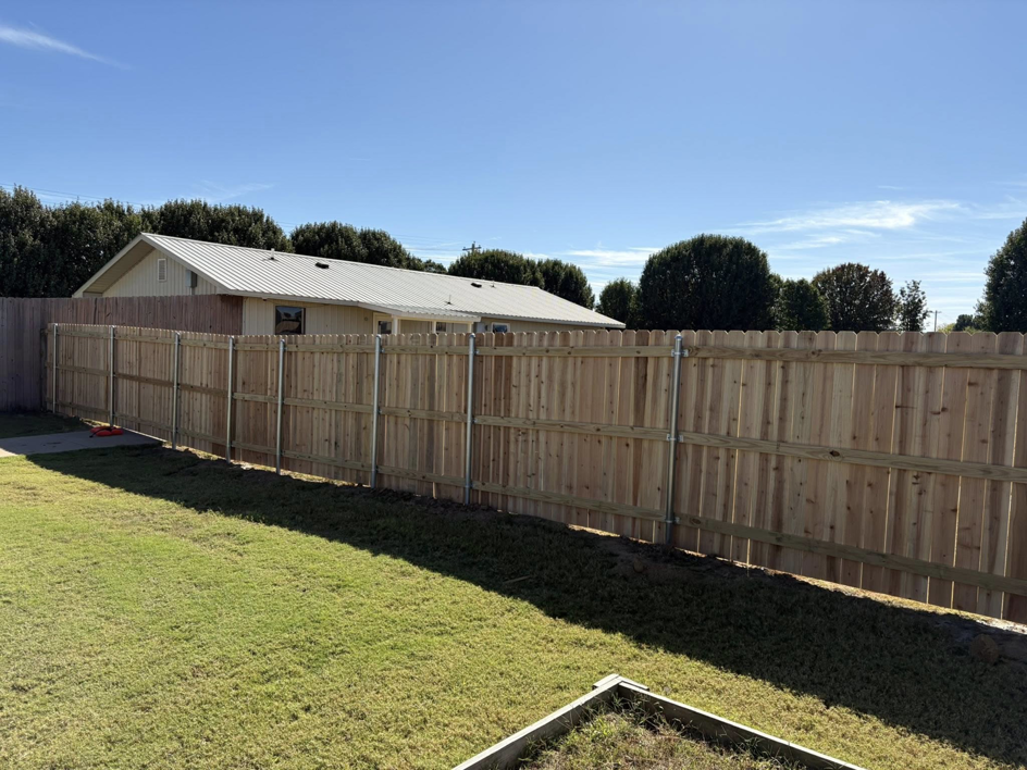 A newly installed wood privacy fence featuring sturdy metal posts by McDaniel Quality Fencing LLC in Muldrow, OK.