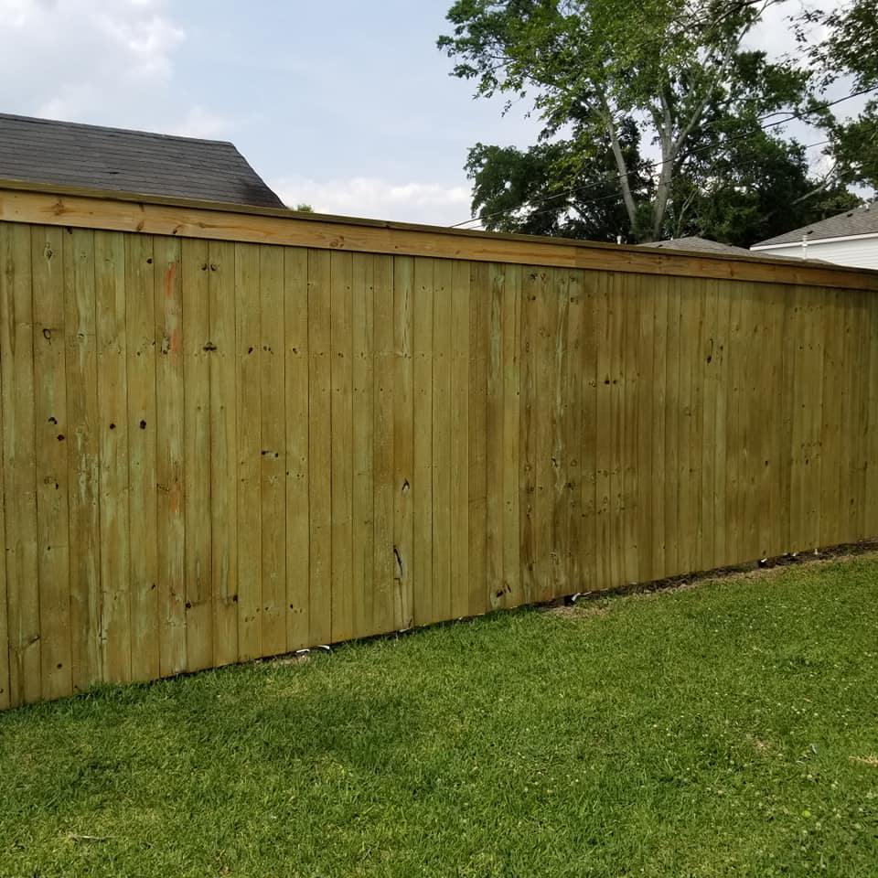 A sturdy wood privacy fence with a decorative top cap installed by Weber Fence LLC in Baton Rouge, LA.