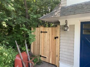 Custom wood privacy gate installed next to a house by Louis Fence installations & repairs in Fall River, MA
