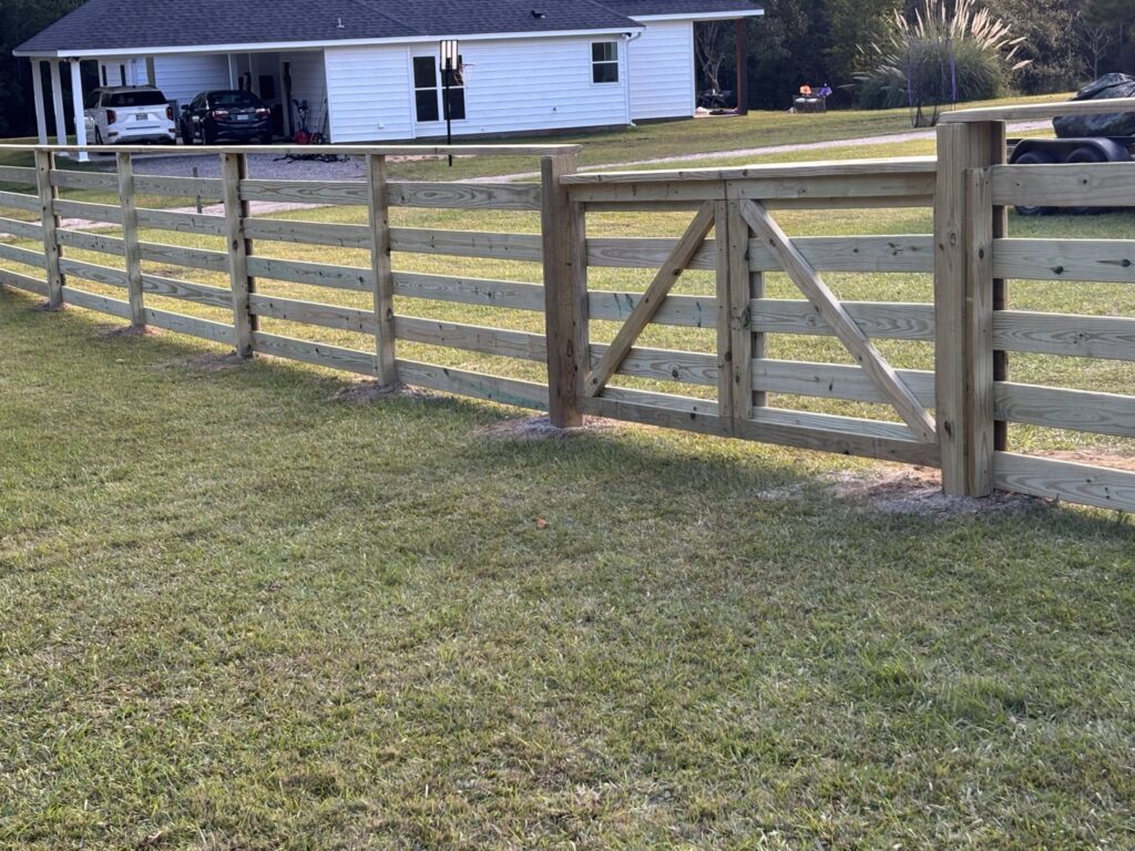 A newly installed wood ranch-style fence with a matching gate by Deep South Services LLC in Biloxi, MS.
