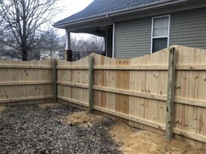 A newly installed wood scalloped fence in a backyard by Fenceitforu LLC in Matthews, NC.