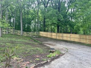A combination of wood split rail and privacy fencing in a wooded area by Fenceworks of Middle Tennessee in Nashville, TN.