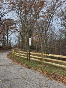 A newly installed wood split rail fence along a paved path by Budget Fence of Ohio in Cleveland, OH.