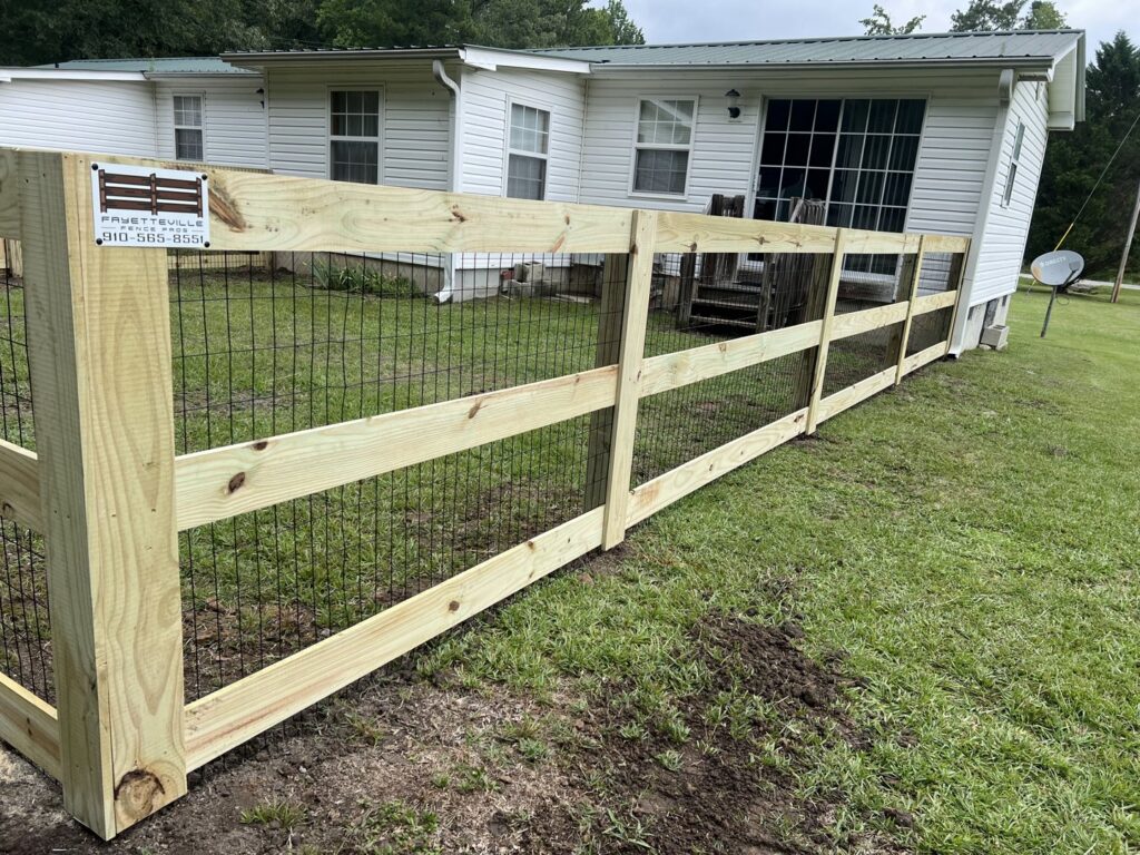 A newly installed wood split-rail fence with wire mesh, built by Fayetteville Fence Pros in Fayetteville, NC.