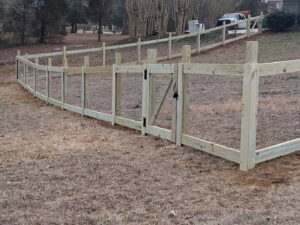 A newly installed wood split-rail fence with wire mesh and a gate by FenceCo LLC in Pass Christian, MS.