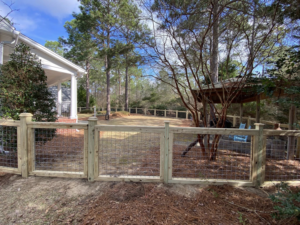 A custom wood and wire mesh gate installed in a backyard fence by Renegade Fencing, LLC in Jacksonville, NC.