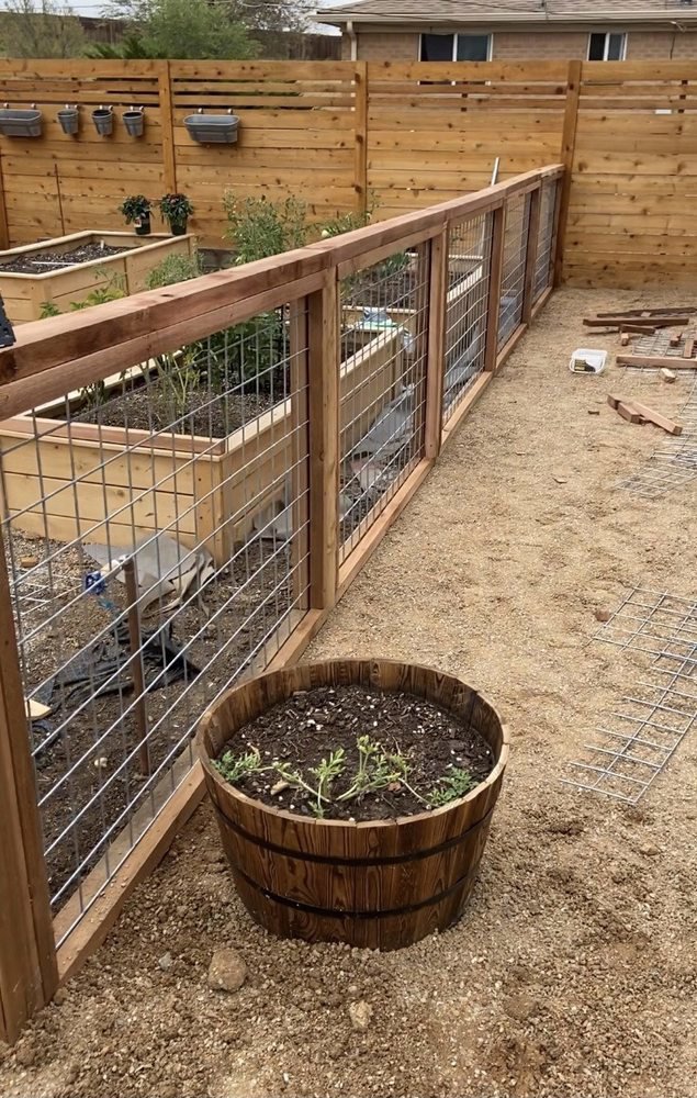 A wooden fence with wire mesh panels, ideal for gardens, installed by R&S Fencing & Design LLC in Denver, CO.