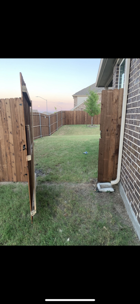 A newly installed wooden fence and gate in a residential backyard by G Squared Fencing & Services LLC in New Braunfels, TX.