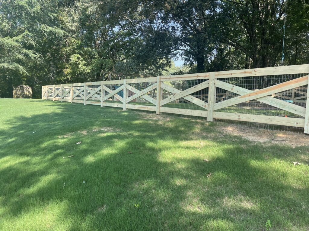 A new wooden cross-buck fence with integrated wire mesh installed by First Responder Outdoor Construction LLC in Bartlett, TN.
