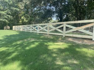 A new wooden cross-buck fence with integrated wire mesh installed by First Responder Outdoor Construction LLC in Bartlett, TN.
