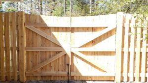 A sturdy wooden double gate with diagonal bracing, part of a new fence installation by Sullivan & Sons Fence LLC in Hudson, NH.